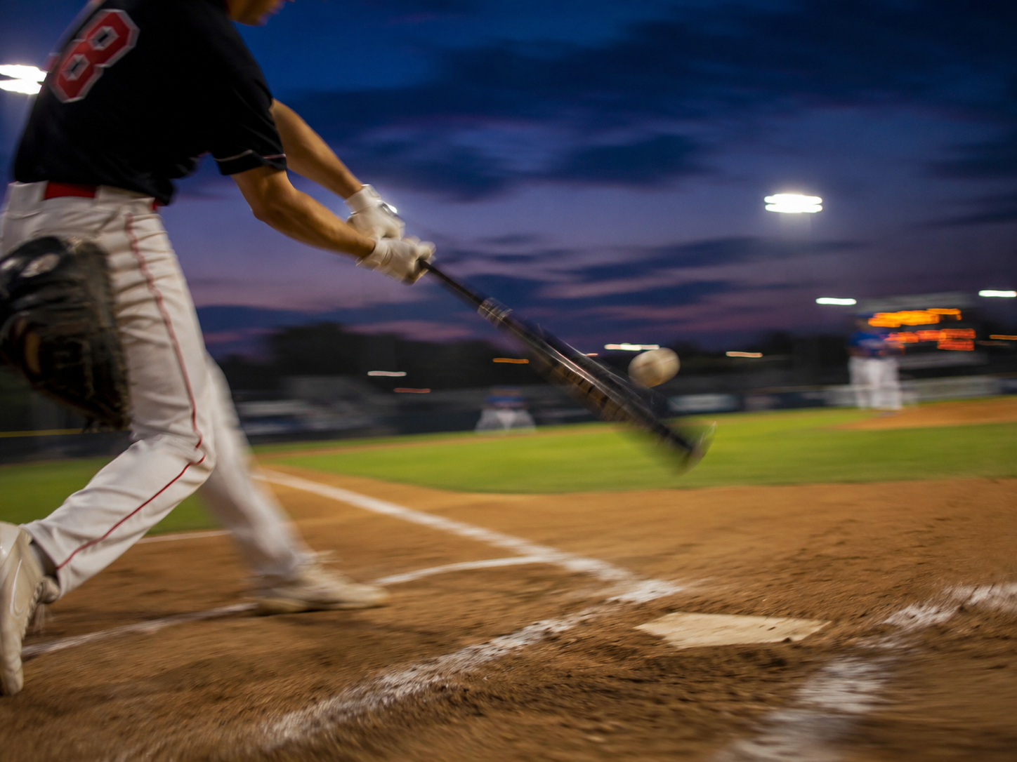 Batter making contact under stadium lights